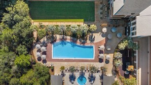 An aerial view of a resort with a swimming pool, lounge areas, and palm trees. - Lazy Duck Retreat by Avantstay Blue Mountain Priv Beach Access Pool + Patio (Santa Rosa Beach)