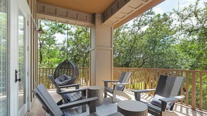 A covered outdoor seating area with chairs and tables, a hanging chair, and a view of trees. - Lazy Duck Retreat by Avantstay Blue Mountain Priv Beach Access Pool + Patio (Santa Rosa Beach)