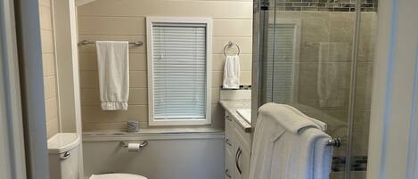 Ein kleines Badezimmer mit Toilette, Duschkabine und Badewanne.