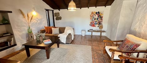 Una sala de estar acogedora con chimenea, un sofá, una mesa de centro y un sillón.
