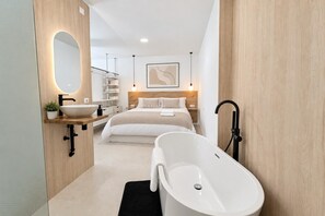 A modern bathroom with a freestanding bathtub, a sink, and a mirror.