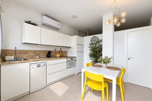 A modern kitchen with white cabinetry, a built-in oven, and a coffee machine. - Live the experience of a stylish Loft! (Aldea Blanca)