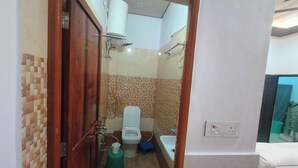 A compact bathroom with a toilet, sink, and shower. - Rudra Inn (Faizabad)