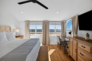Une chambre d’hôtel moderne avec un grand lit, un bureau et une vue sur la plage.