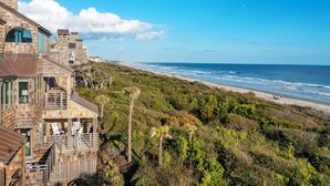 A coastal building with multiple balconies overlooking a beach.