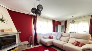 Una sala de estar con chimenea, un sofá, una mesa de centro y una alfombra roja.