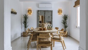 A dining area with a round table, wooden chairs, and potted plants. - Villa Artista (Javea / Xàbia)