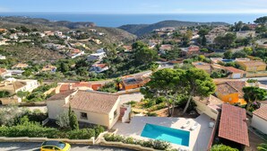 Un quartier résidentiel situé sur la côte, avec des maisons, une piscine et une vue sur la mer.