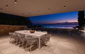 An outdoor dining area with a view of the sea at sunset. - Stunning home in Zdrelac (Zdrelac)