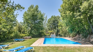 A swimming pool with lounge chairs, surrounded by trees. - Apartment 'Apartamento La Cuadra' with Mountain Views, Shared Pool, and Wi-Fi (La Zubia)