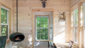 Ein Blockhaus-Interieur mit Kamin, Schreibtisch, Stuhl und einem an der Wand aufgehängten Hirschkopf.
