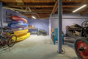 A garage with kayaks, bicycles, and a chair. - Minutes to Beach Pool Intracoastal Free Kayaks/Bikes, Intracoastal Sea Life Retreat (Holly Hill)