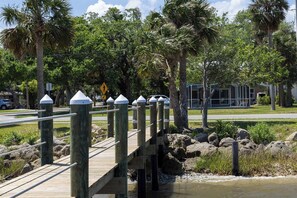 A wooden bridge with metal railings, surrounded by palm trees and a body of water. - Minutes to Beach Pool Intracoastal Free Kayaks/Bikes, Intracoastal Sea Life Retreat (Holly Hill)