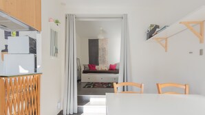 A modern kitchen with a refrigerator, wooden cabinets, and a dining area with a table and chairs. - Chalet "De Sers" with Mountain Views, Private Terrace and Wi-Fi (Sers)