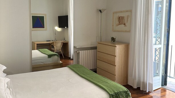 A bedroom with a bed, a dresser, a chair, a desk, and a radiator. - Spanish Steps Luxury Double Room (Roma)