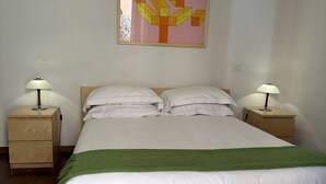 A double bed with white linens, two bedside tables with lamps, a green throw blanket, and a wall painting. - Spanish Steps Luxury Double Room (Roma)