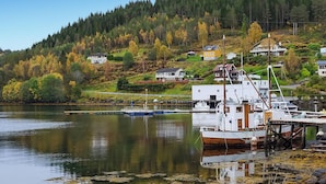 A marina with boats docked, a dock extending into calm water, and houses on a hillside in the background. - 3 bedroom nice home in Mjosundet (Mjosundet)