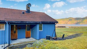 A blue house with a red-tiled roof, a chimney, and a door. - 3 bedroom nice home in Mjosundet (Mjosundet)