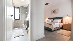 A modern bedroom with a bed, bedside tables, and a nightstand. - StunNing home in Nin with sauna (Nin)