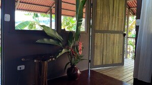 Une pièce avec une table en bois, une plante en pot et une porte en bambou.