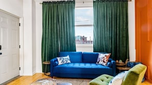 A room with a blue sofa, green armchair, and a small round table. - Sleeps 12, HOT TUB, Cowboy Pool, Firepits, Yard Games (Louisville)