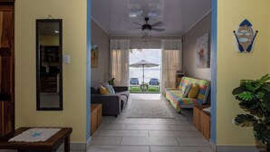 A spacious living area with a sofa, a coffee table, and a ceiling fan. - Mar & Sombra Villas (Quepos)