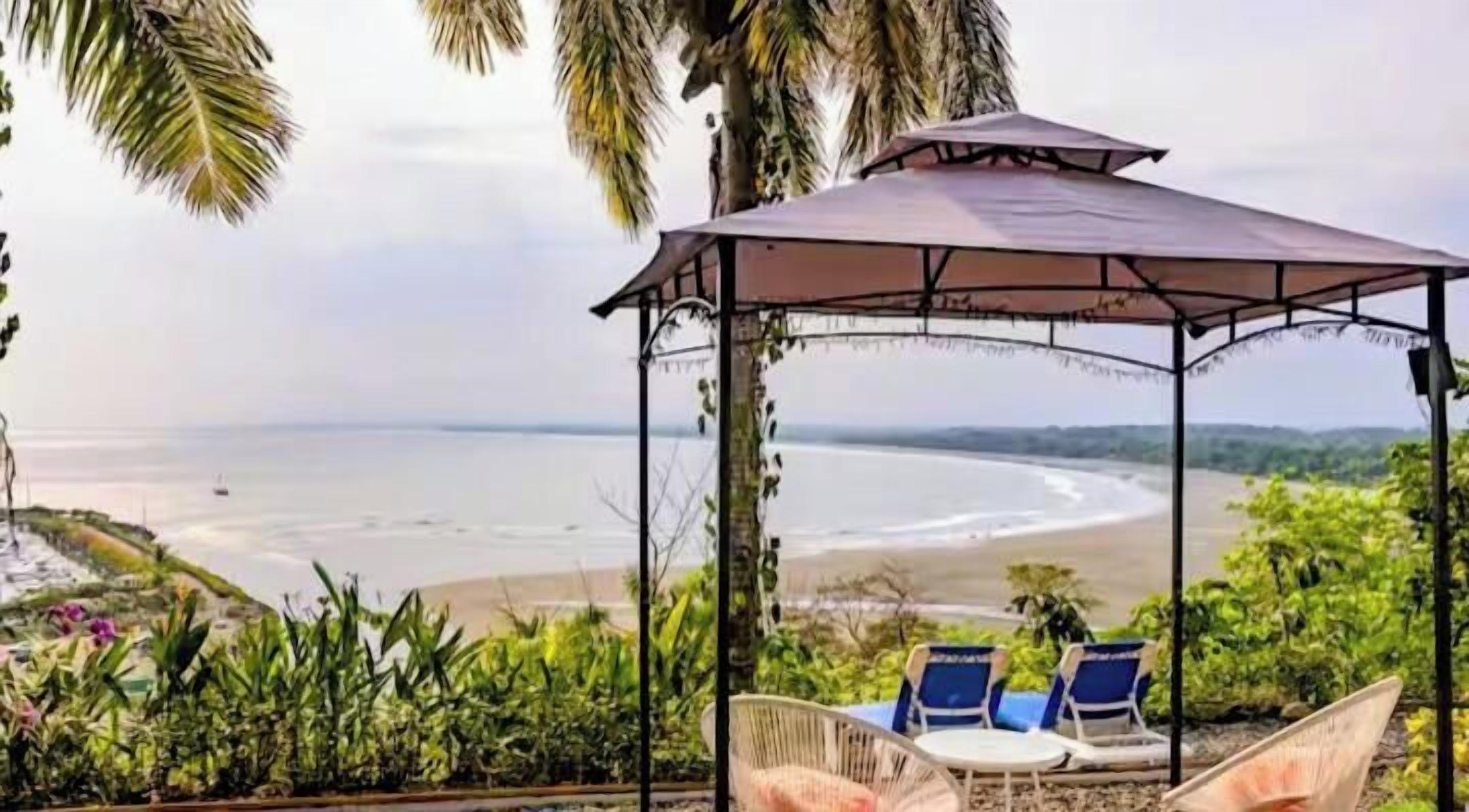 A covered seating area with a view of the beach.