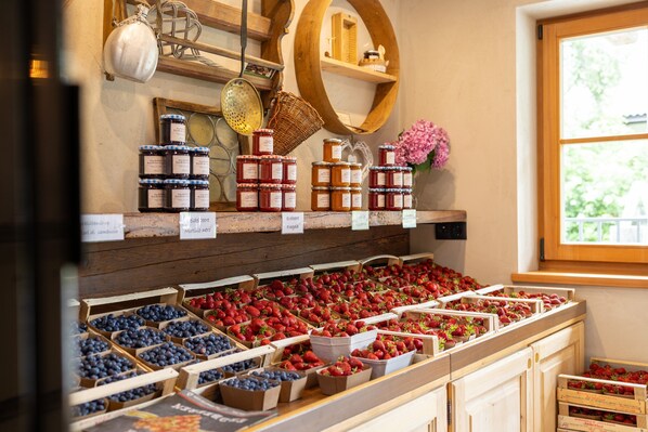 A variety of fruits and jams displayed in wooden crates and jars.