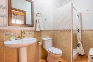 A bathroom with a sink, toilet, and shower curtain.