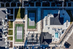An aerial view of a residential area with multiple tennis courts, a swimming pool, and a parking lot. - Snowbasin Retreat R5966 | Hot Tub | By Ski Resorts (Mountain Green)