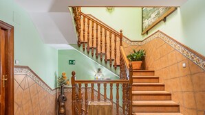 A staircase with wooden balusters, a potted plant, and a tiled wall. - Apartment 'Apartamento De 1 A 2 Personas' with Balcony and Wi-Fi (Güejar Sierra)