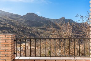 A balcony with a view of a mountainous landscape.