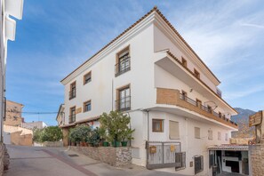 Un immeuble à plusieurs étages, doté de balcons, d’une entrée sécurisée et d’un commerce visible au rez-de-chaussée.
