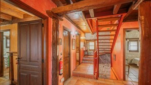 A wooden staircase leading to an upper floor, a wooden door, and a tiled floor.