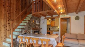 Un intérieur en bois comprenant un coin repas, un escalier et une cuisine.