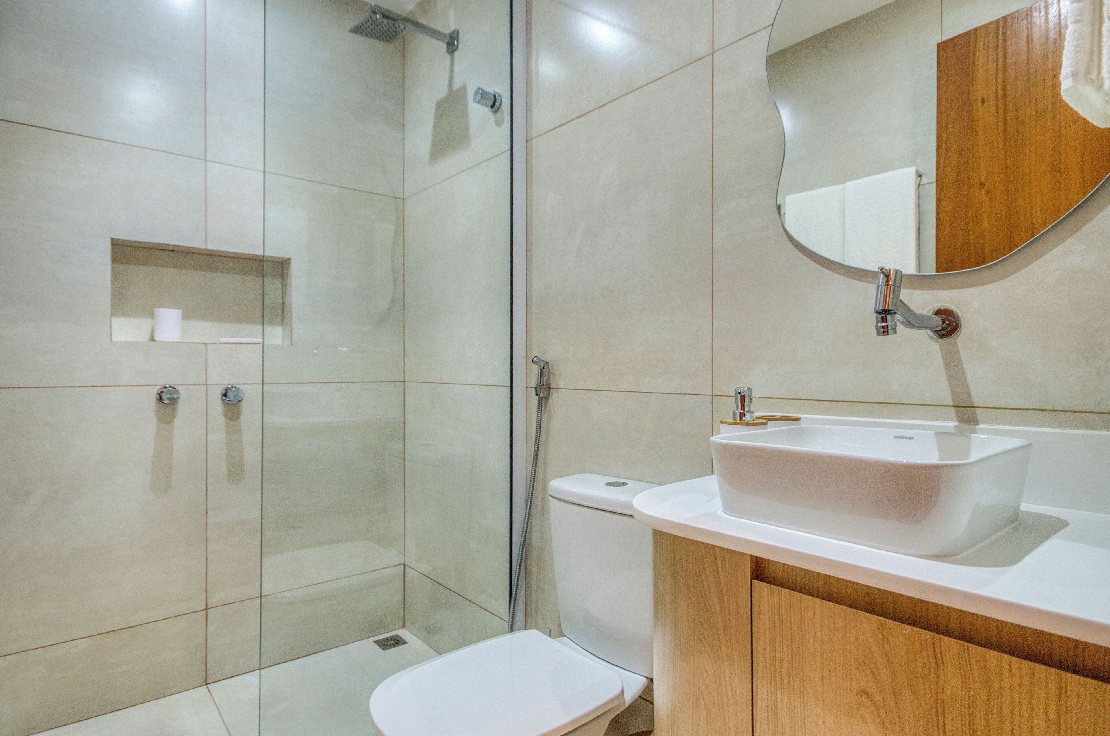 A modern bathroom with a glass-enclosed shower, a white toilet, and a vanity with a sink.