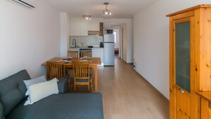 Eine moderne Wohnung mit Essbereich, Küchenzeile und einem Holzschrank.