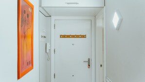 A white door with a coat rack, a light switch, and a wall-mounted light fixture. - WELCS APARTAMENTO 190 EMP cerca del mar (Empuriabrava)