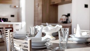 Una mesa de comedor dispuesta con platos, tazones y un vaso.