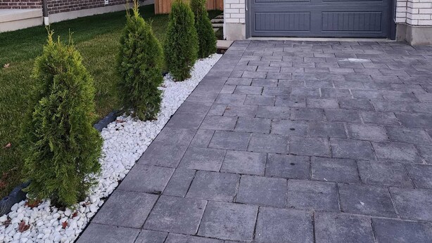 A residential driveway with a paved walkway, a garage door, and a wooden fence. - Homely, cozy, spacious quiet basement apartment in a lovely neighborhood.  (Thamesford)
