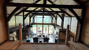 Un interior rústico de madera con techo alto y ventanas amplias.