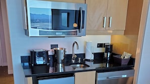 Una cocina compacta equipada con microondas, cafetera y lavavajillas.