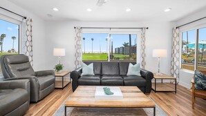 A living room with a leather sofa, a coffee table, and two side tables with lamps. - Beachside Oasis in Newport Beach – Steps to Balboa Park, Pier, and The Fun Zone! (Newport Beach)