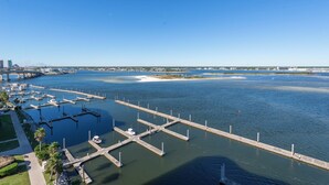 A marina with docks and boats, a bridge in the background, and a clear sky.