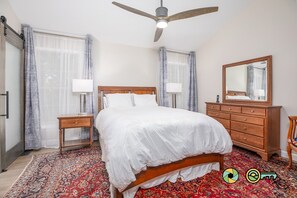 A bedroom with a bed, a dresser, a nightstand, a ceiling fan, and a large mirror. - Pine Cone Paradise - escape to luxury! (Mount Jackson)
