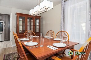 A dining room with a wooden table set for six, surrounded by wooden chairs. - Pine Cone Paradise - escape to luxury! (Mount Jackson)