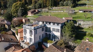 Un edificio grande de varios pisos con una sección central destacada, rodeado de casas más pequeñas.
