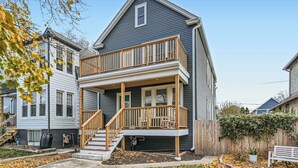 A two-story house with a balcony, a front porch, and a visible staircase.