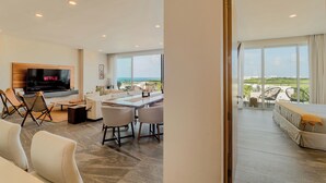 Quarto de hotel moderno com uma televisão grande, área de refeições e varanda com vista para o mar.