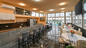 A modern kitchen with a bar area, large windows, and a dining space with a view.